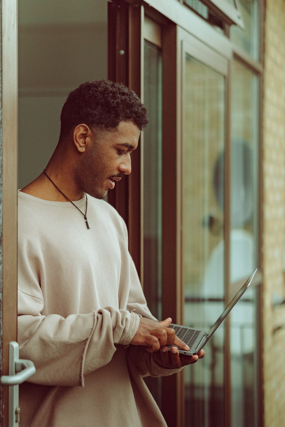 man in white sweater holding tablet computer