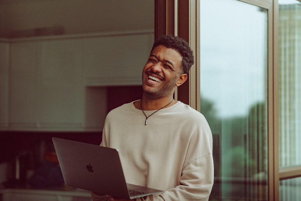 man in white long sleeve shirt sitting in front of silver macbook