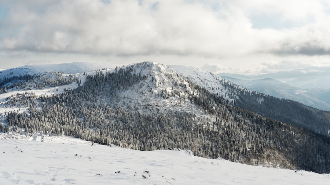 snow covered mountain under cloudy sky during daytime