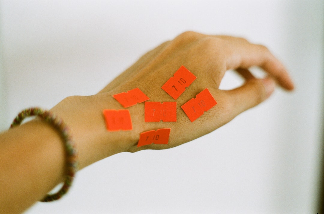 person holding orange and white textile