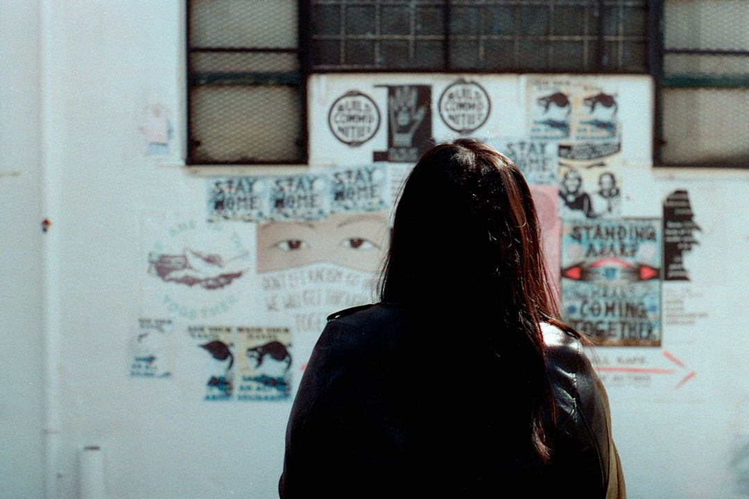 woman in black hoodie standing in front of white wall