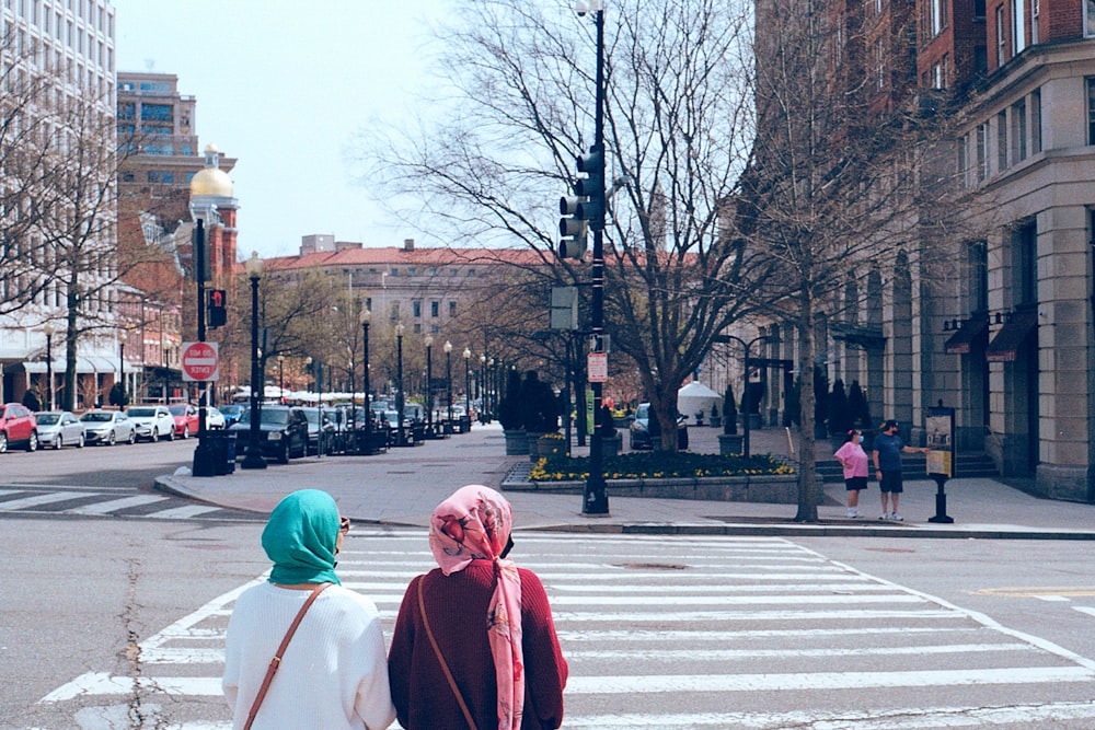 person in red hoodie walking on pedestrian lane during daytime