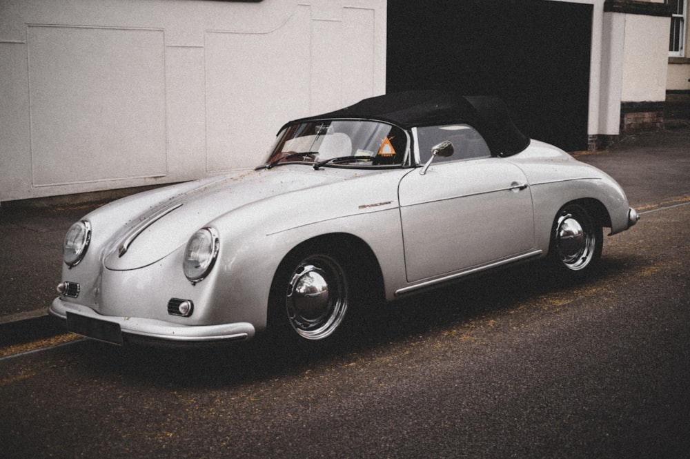 white convertible coupe parked beside white wall