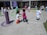 A group of children joyfully painting colorful pictures outdoors on a sunny day.
