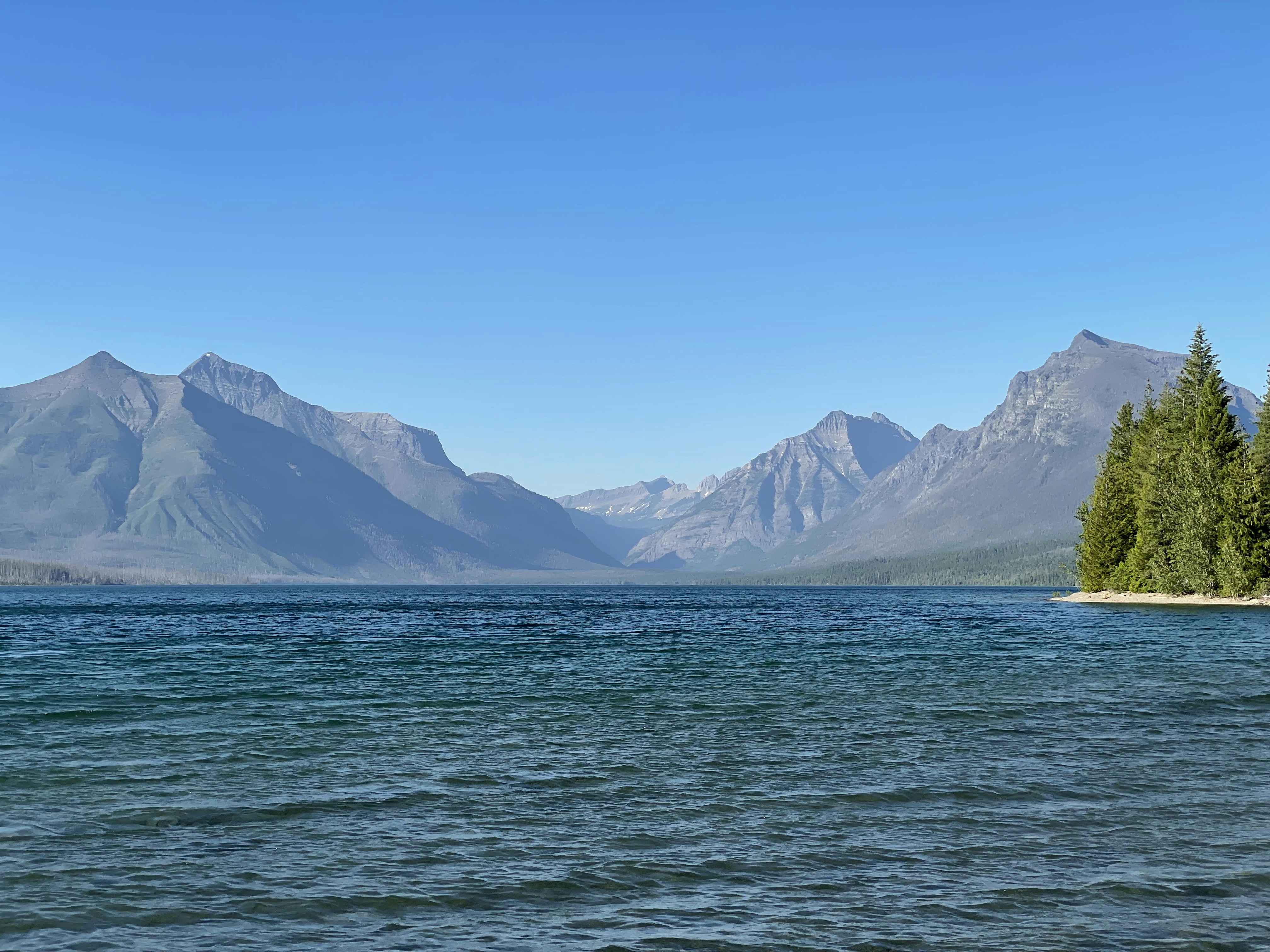 body of water near mountain during daytime