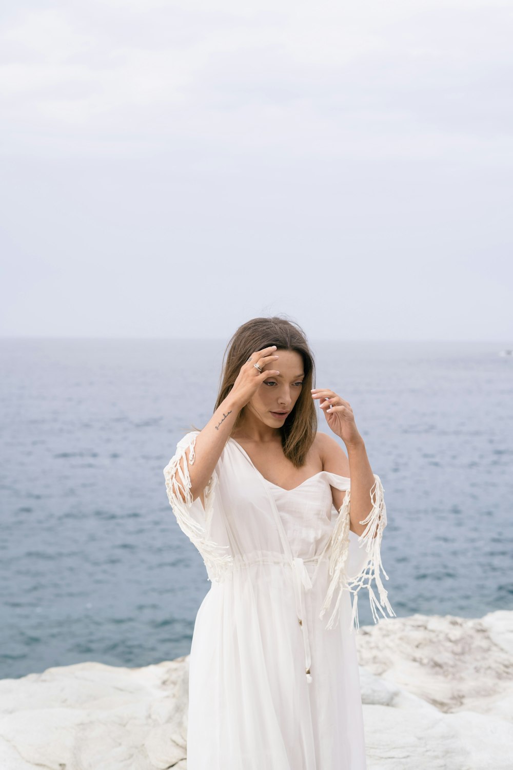 woman in white dress standing on beach during daytime