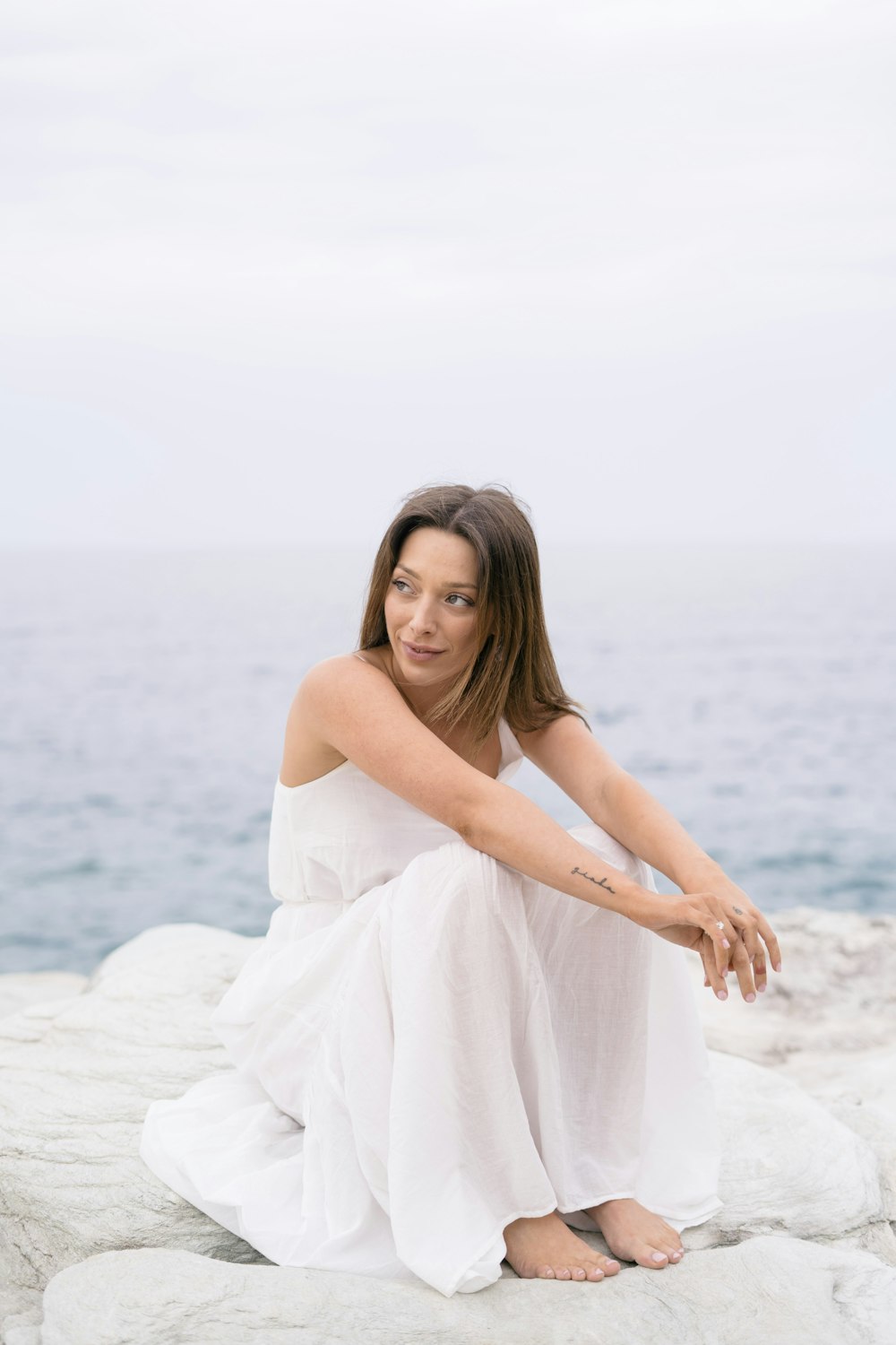 woman in white dress standing on white sand during daytime