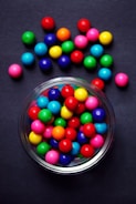 red green blue and yellow m ms candies in clear glass bowl