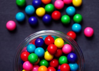 red green blue and yellow m ms candies in clear glass bowl