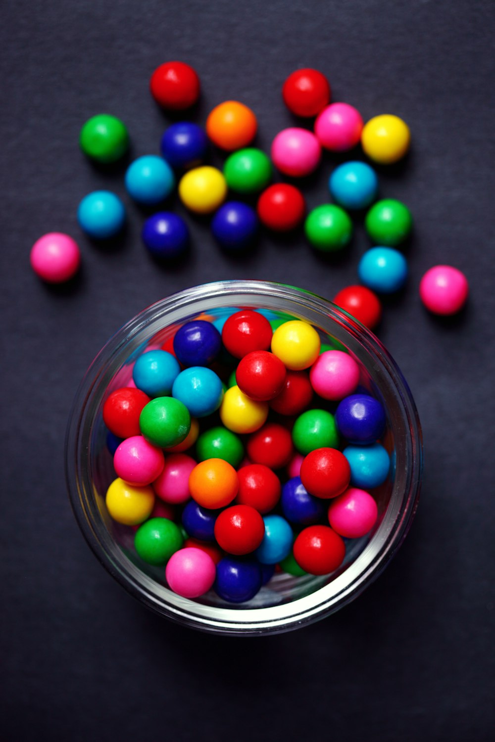 Bonbons M MS rouges, verts, bleus et jaunes dans un bol en verre transparent