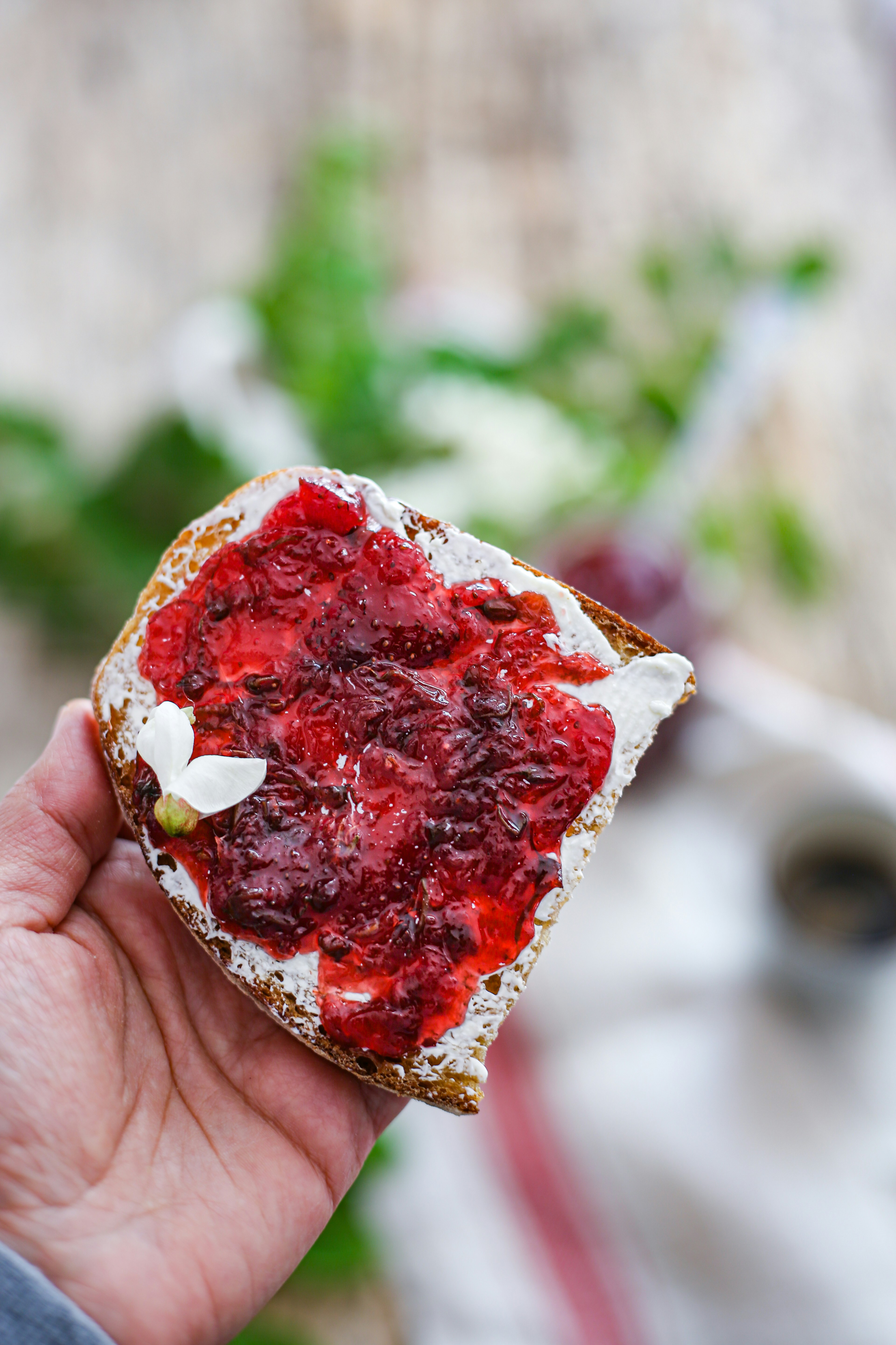 person holding red and white heart shaped cake