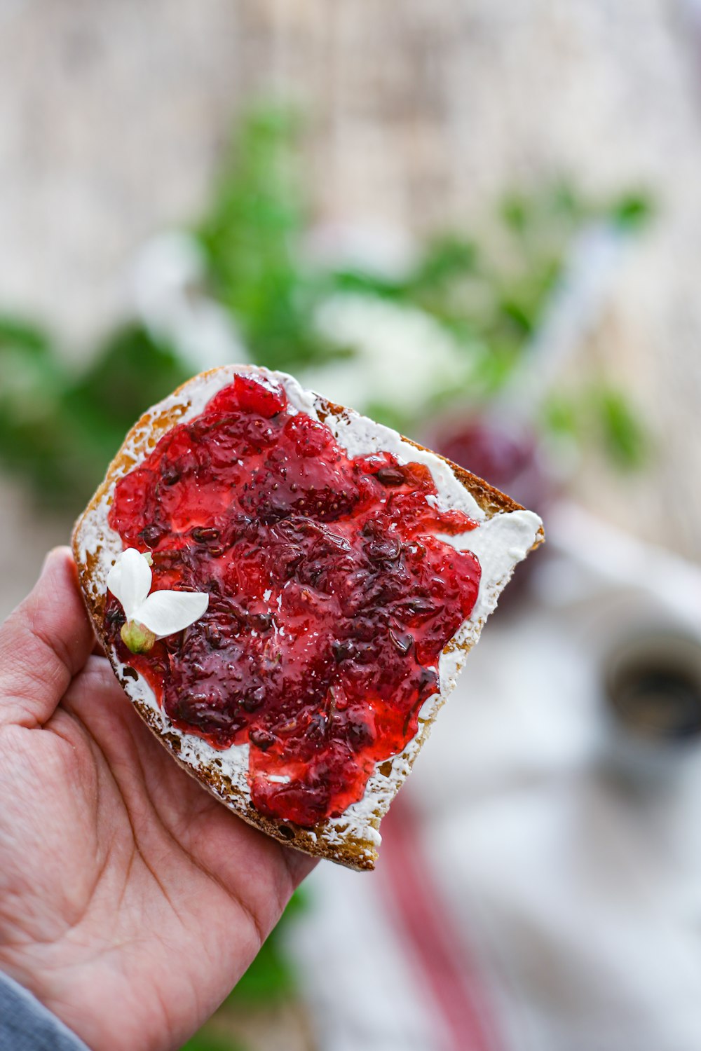 person holding red and white heart shaped cake