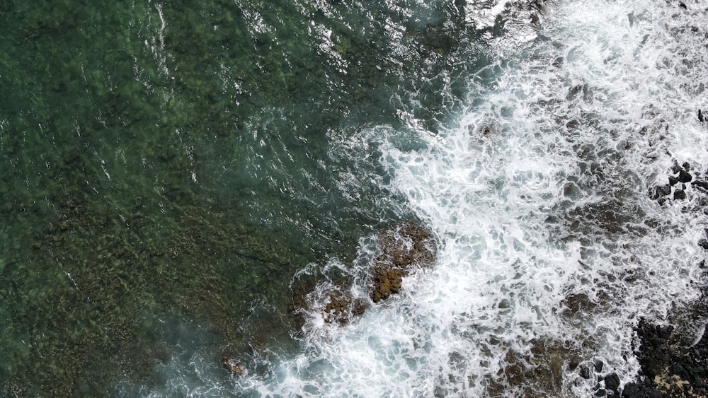 water waves hitting rocks during daytime