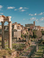 Ancient Roman ruins and the Colosseum under a blue sky in Rome