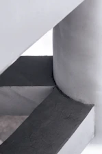 High-resolution photo of a minimalist concrete structure highlighting its hybrid reinforcement details.