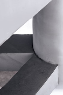 Close-up of a monolithic geometric concrete architectural element with smooth texture in a minimalist setting