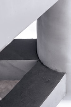 Artisan crafting a minimalistic geometric precast concrete architectural element in a studio.