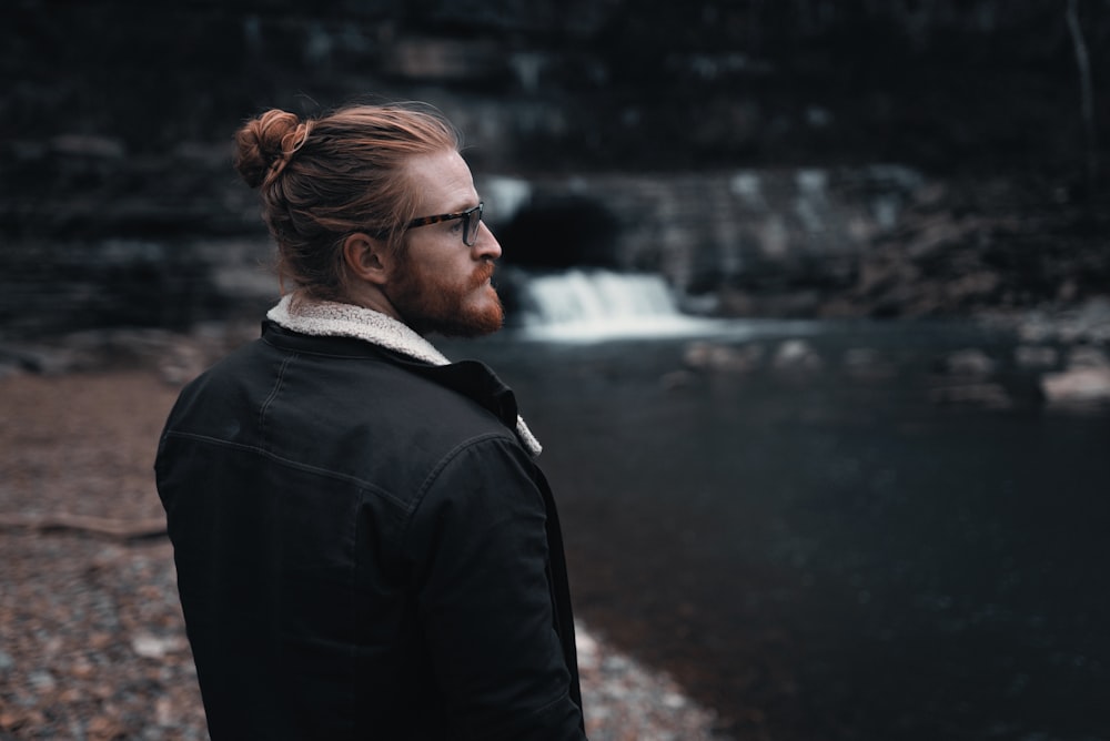 man in black jacket standing near river during daytime