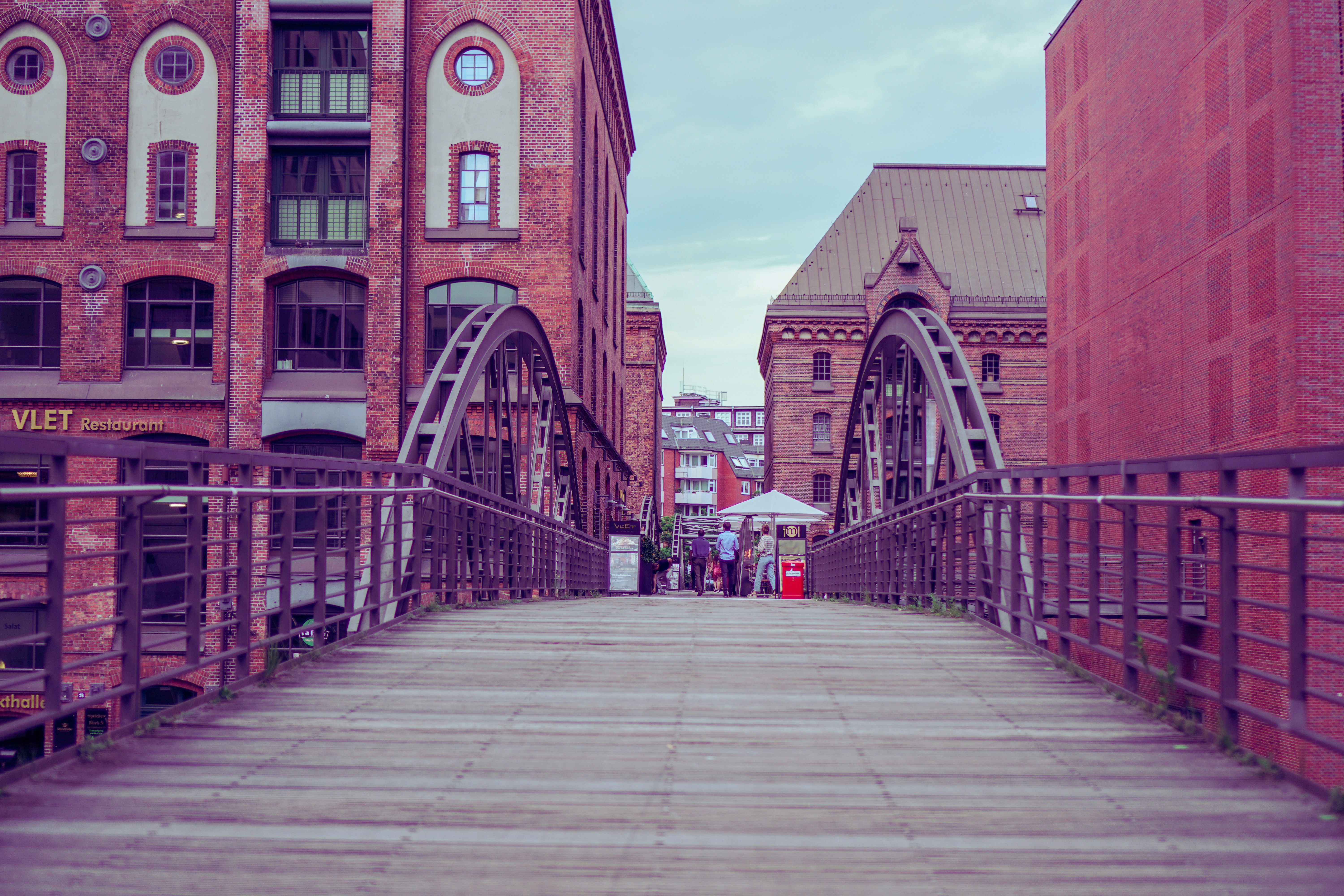 people walking on bridge near brown concrete building during daytime