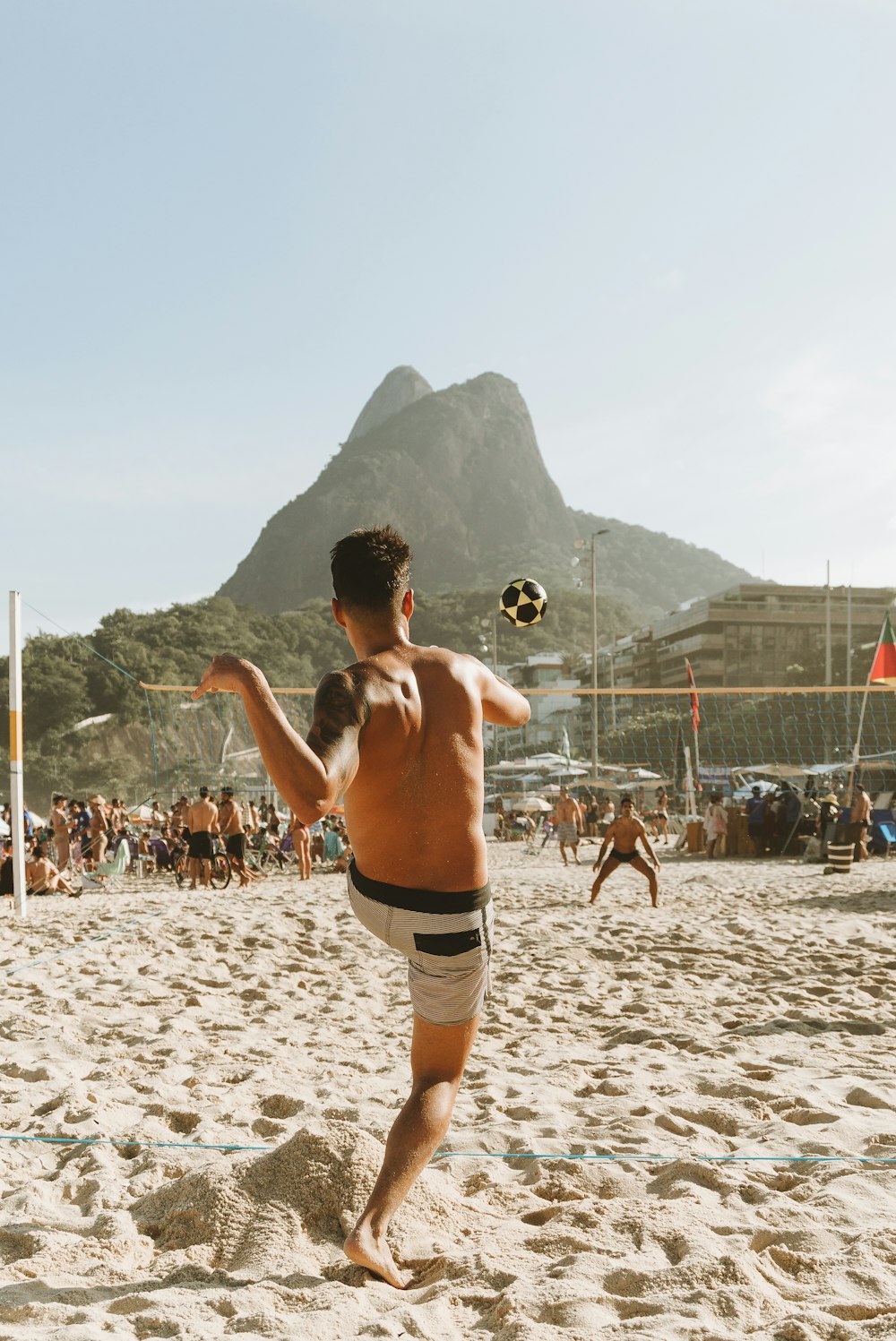 topless man in black shorts running on white sand during daytime