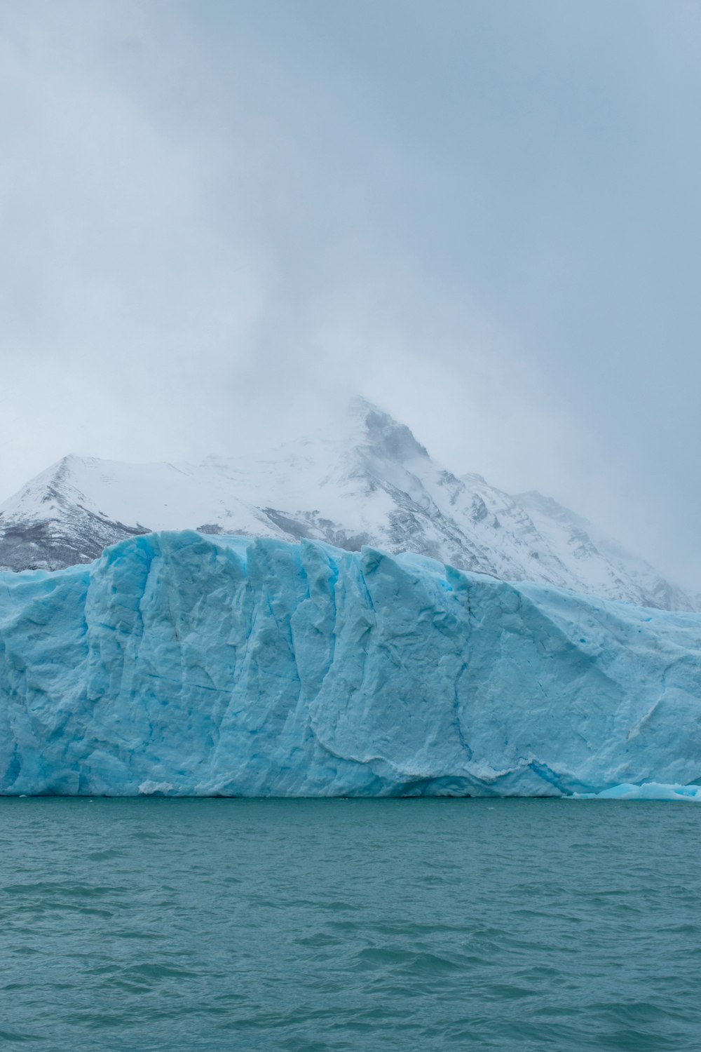 white snow covered mountain near body of water during daytime