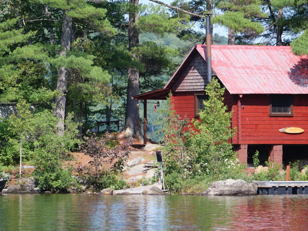 red and brown wooden house near river during daytime