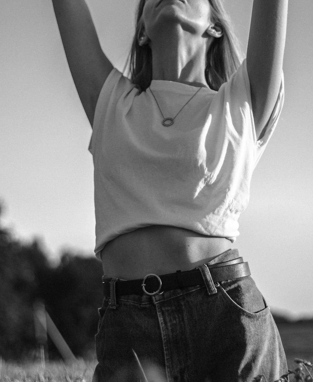 woman in white tank top and blue denim jeans