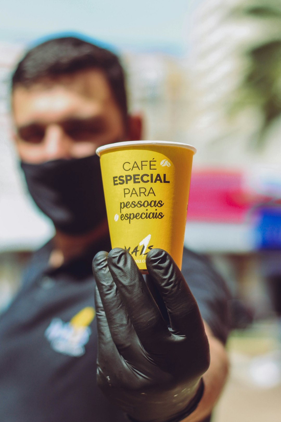 yellow plastic cup on black leather gloves