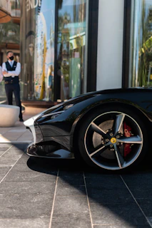 black car parked near woman in white dress
