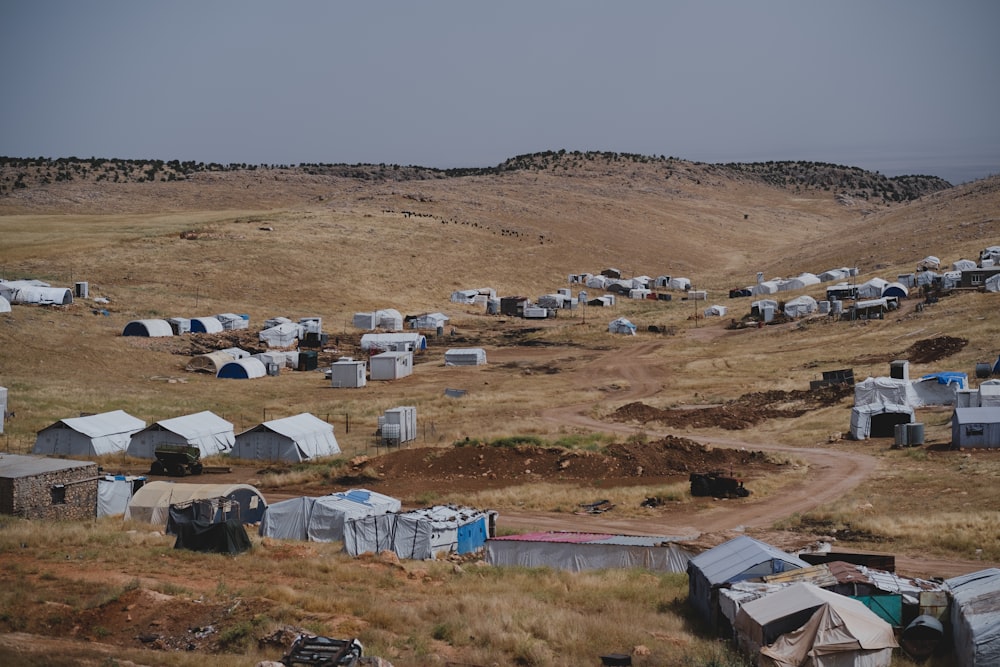 white and brown houses on brown field during daytime