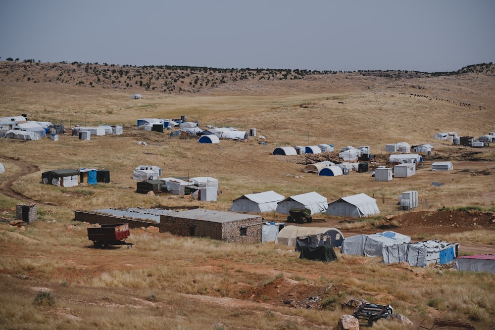 white and brown houses on brown field during daytime