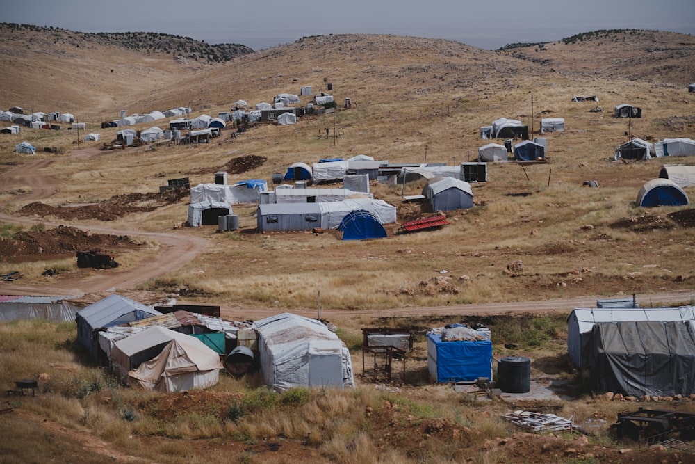 Tente blanche et brune sur un terrain brun pendant la journée