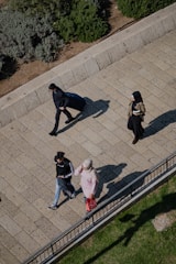 man in black jacket and blue denim jeans standing beside woman in black jacket