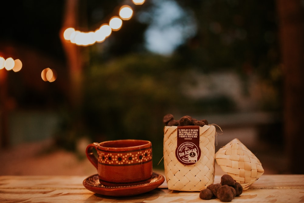 white and red ceramic mug on brown wooden table