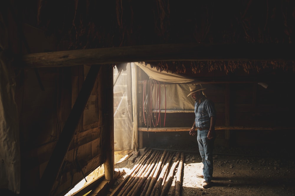 man in blue denim jeans standing on brown wooden plank