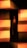 A cigar stands vertically in the center surrounded by blocks of glowing light in shades of orange and yellow, creating an abstract and moody composition.