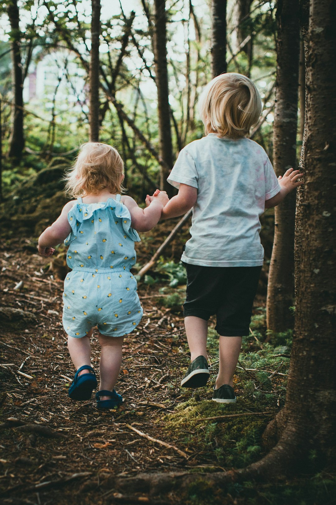 2 girls standing on forest during daytime