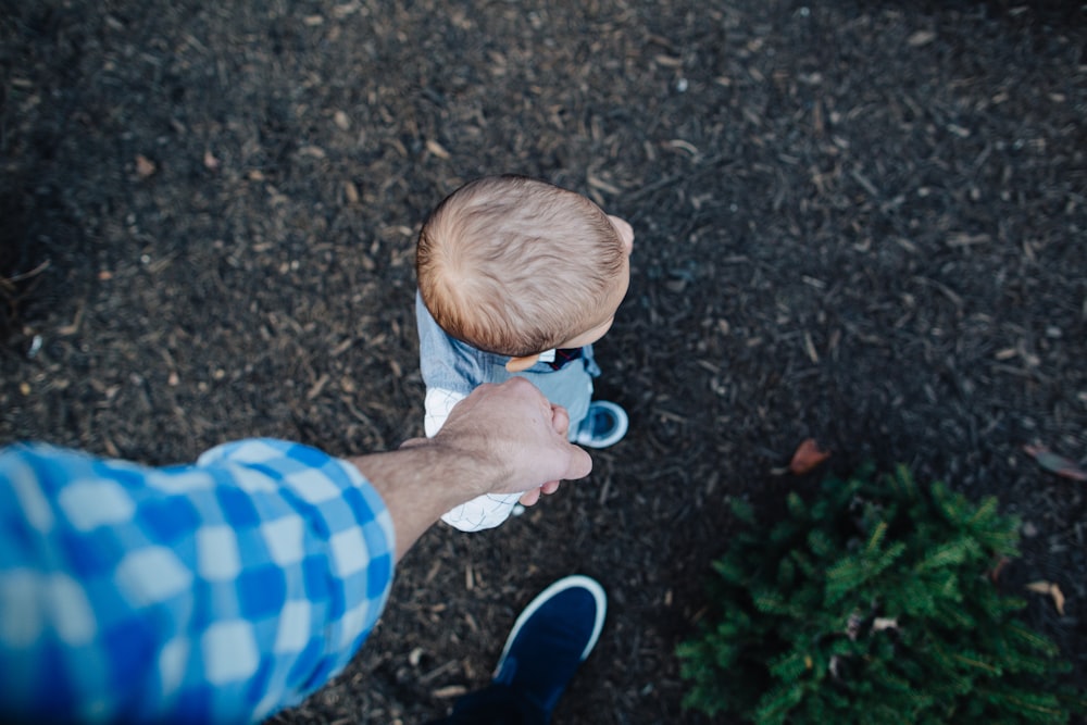 boy in blue and white striped shirt holding blue and white ball