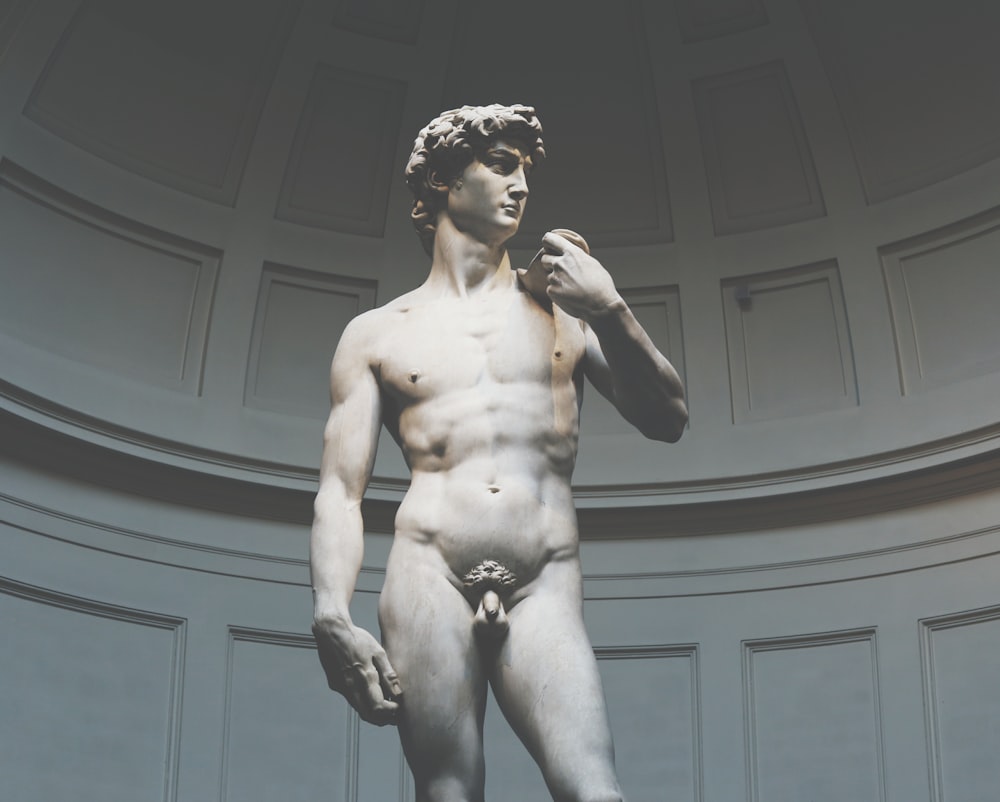 estatua de hombre en topless en fotografía en escala de grises