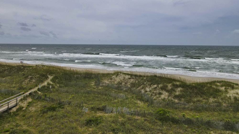 a sandy beach with a wooden walkway leading to the ocean