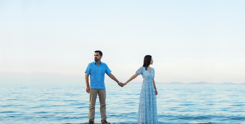 낮 동안 해변을 걷는 동안 손을 잡고 있는 남자와 여자