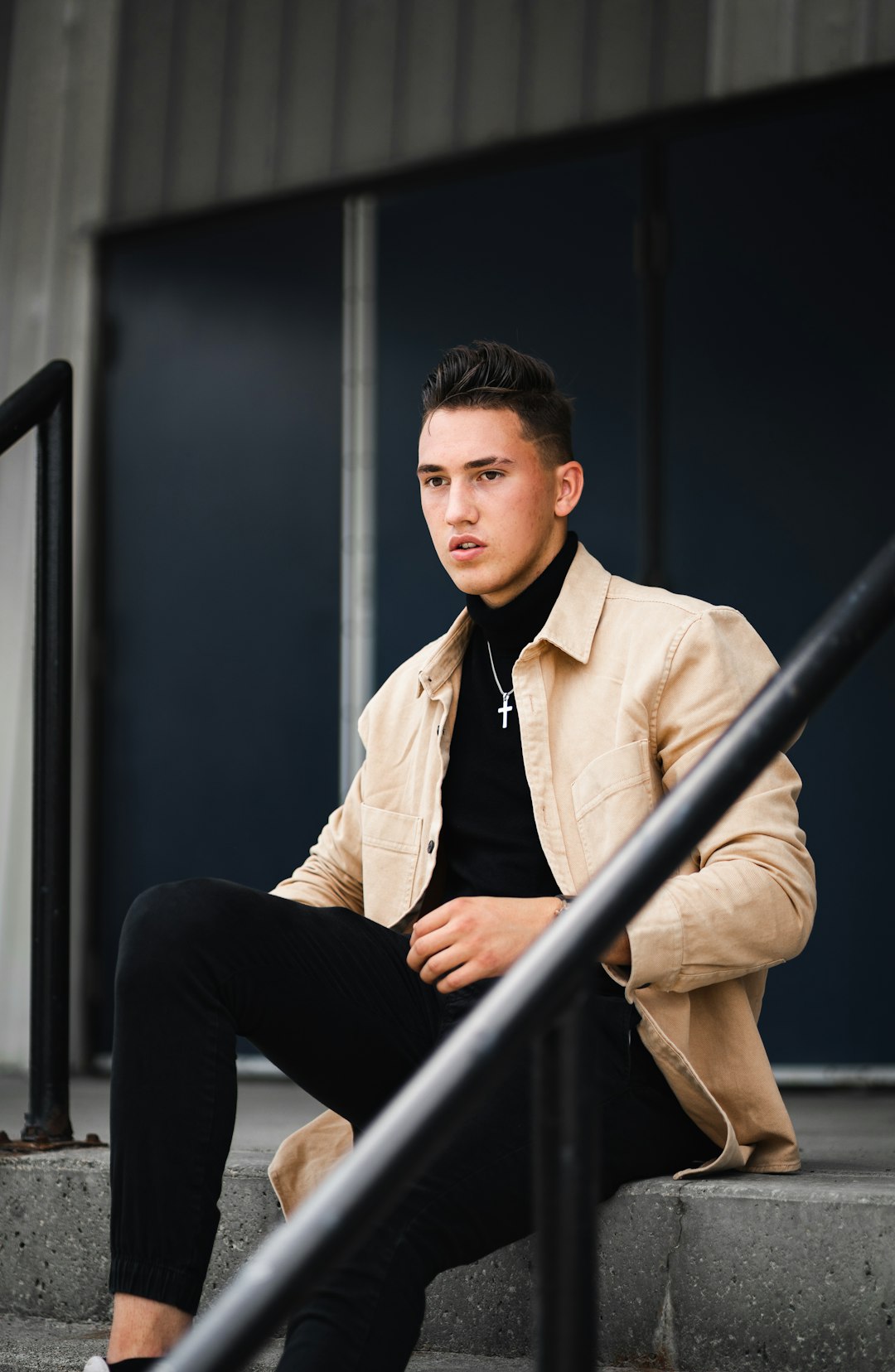 man in brown suit jacket and black pants sitting on black chair