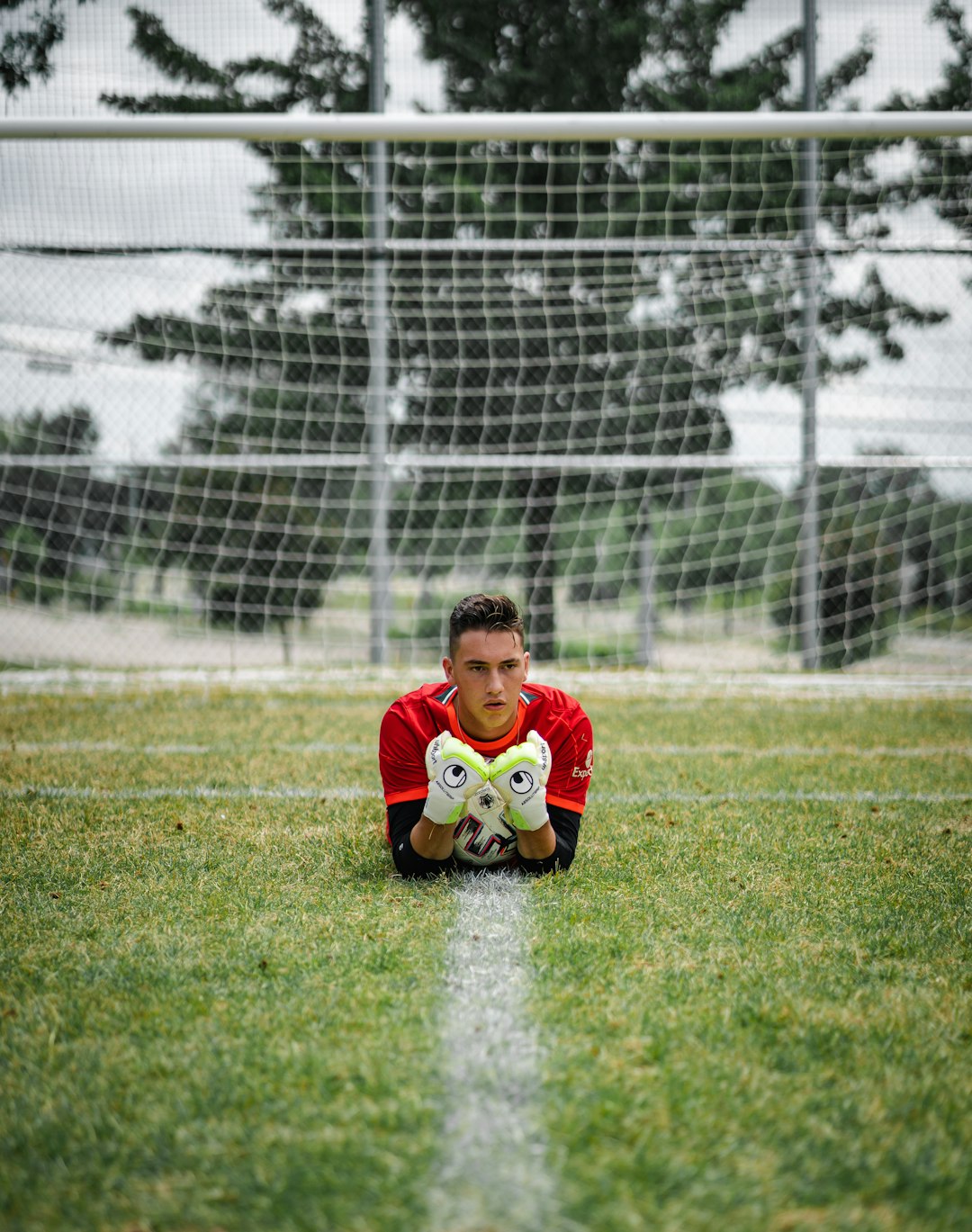 boy in red shirt sitting on green grass field during daytime