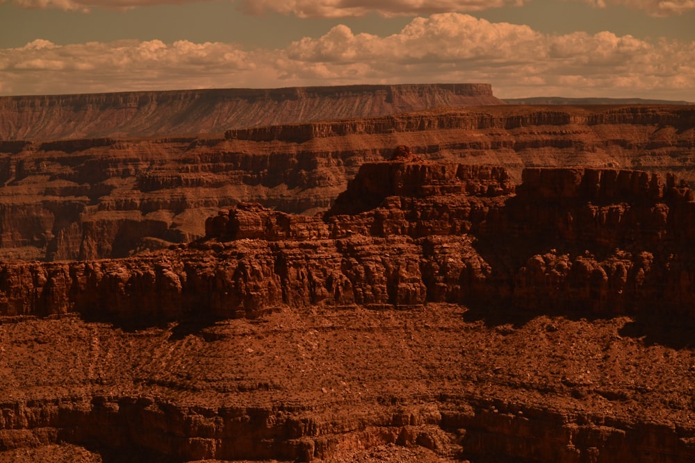 brown rock formation under white clouds during daytime