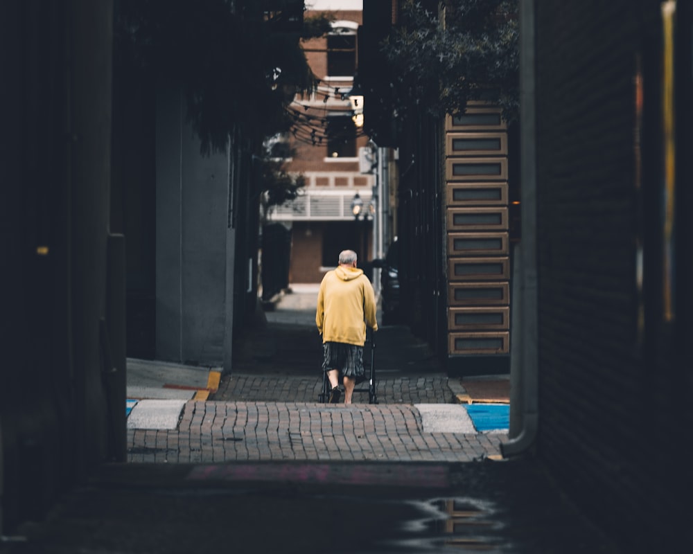 man in white dress shirt and black pants walking on sidewalk during night time