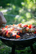 person holding fork and knife slicing meat on black grill