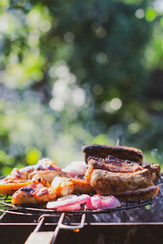 A modern barbecue rack holding perfectly grilled meats and vegetables outdoors.
