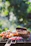 A vibrant outdoor barbecue setup with various grilling tools and meats ready to cook.
