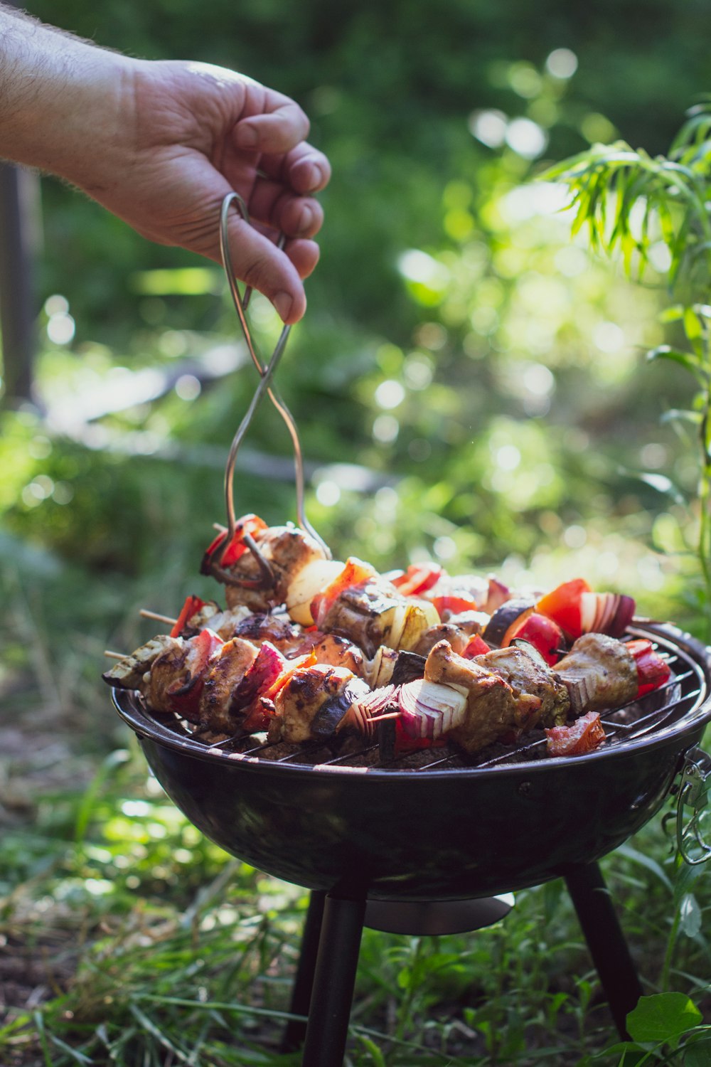 Person, die eine schwarze Keramikschüssel mit gekochtem Essen hält