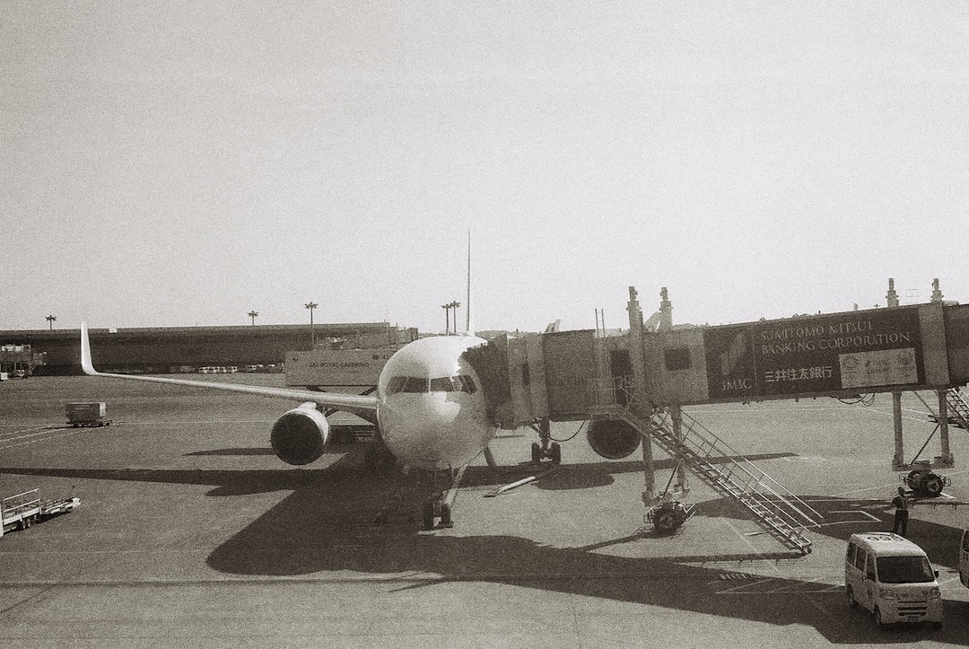 white airplane on gray concrete ground during daytime